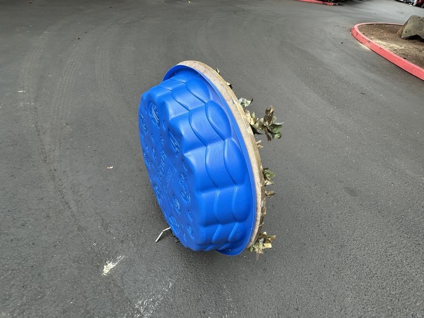 Prototype VII's rear panel: a kiddie pool set into the plywood back, resting on the pavement